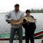 Father and son holding a pike